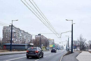 Опори контактної мережі з кронштейнами вздовж дороги в місті