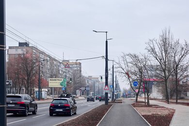 Опоры контактной сети с кронштейнами рядом с городской дорогой