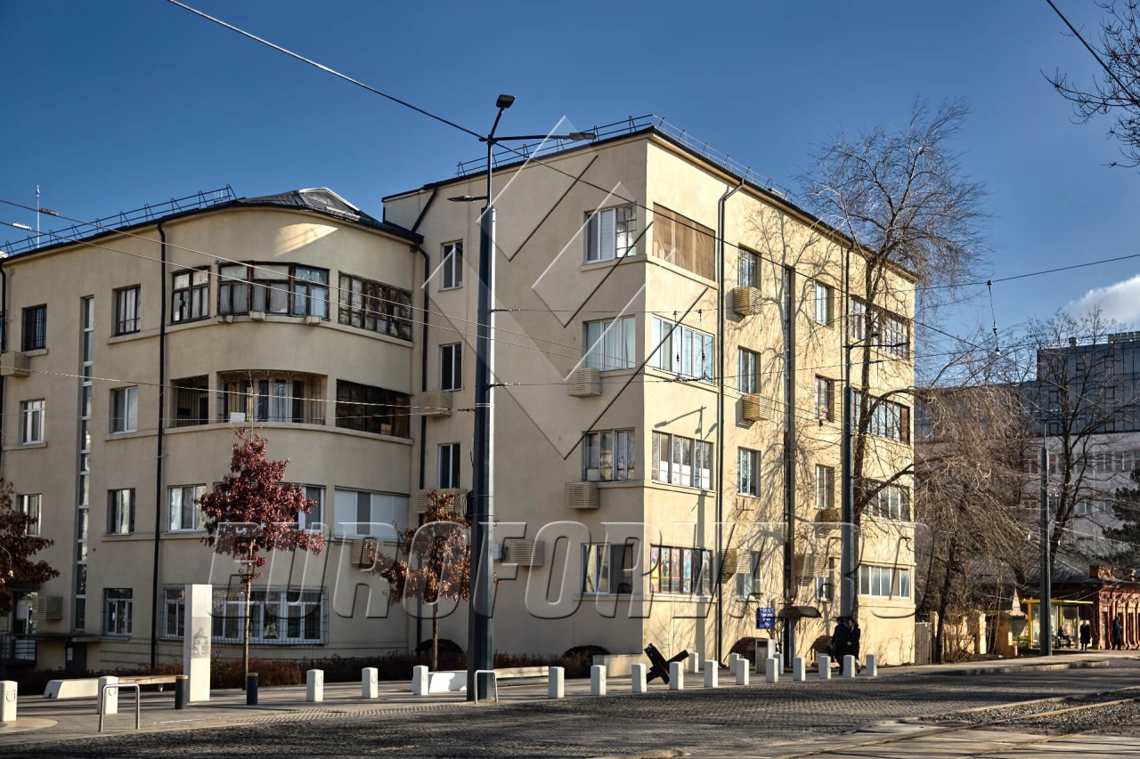 Опоры контактной сети многогранные рядом с дорогой и зданиями в городе