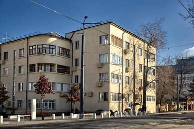 Опоры контактной сети многогранные рядом с дорогой и зданиями в городе