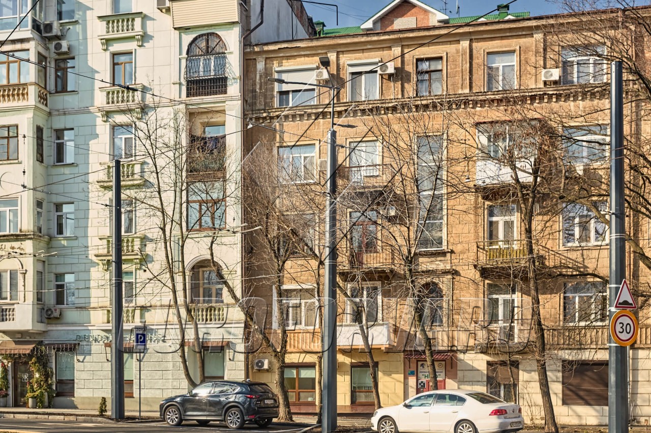 Опоры контактной сети многогранные на фоне зданий города